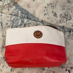 Michael Kors, medium wristlet. in tangerine & cream. It is in vintage condition.
